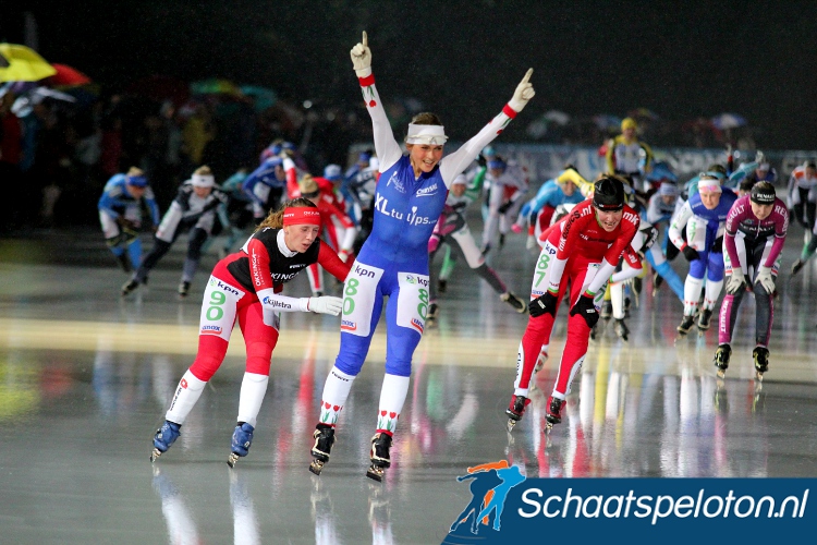 Irene Schouten komt in de stromende regen als eerste winnares van het seizoen over de streep.